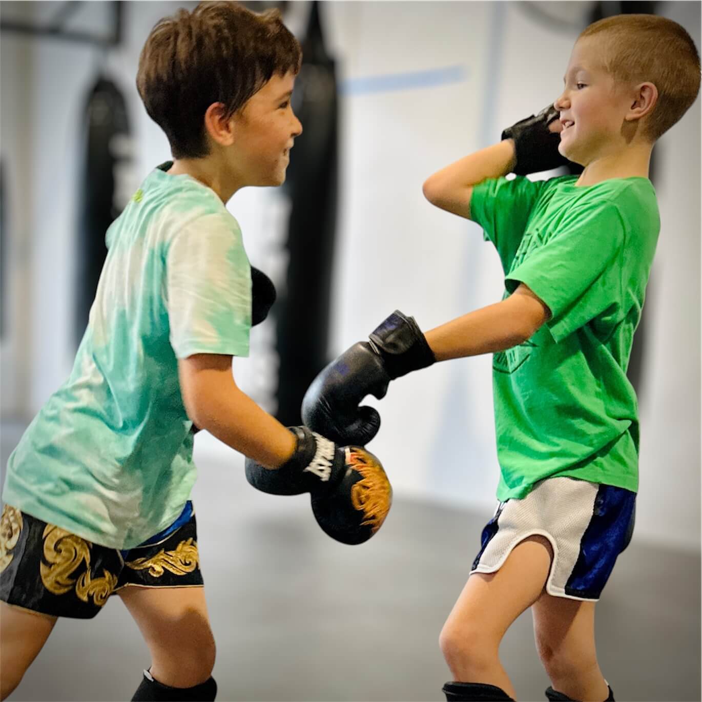 Two children enjoying Muay Thai training together